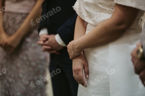 Preview: Shallow focus shot of a bride standing next to the groom and other people