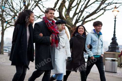Preview: Friends Walking Along South Bank On Winter Visit To London