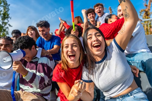 Preview: Young friends cheering at sports event celebrating victory