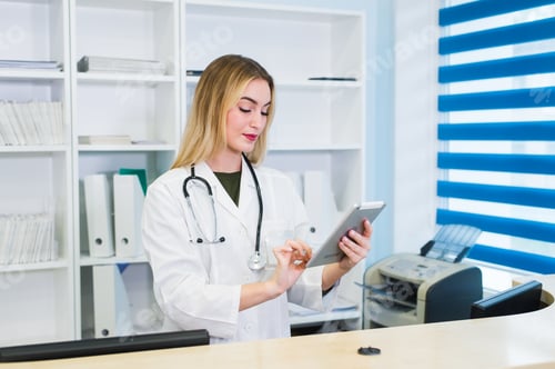 Young female receptionist holding tablet computer in hospital
