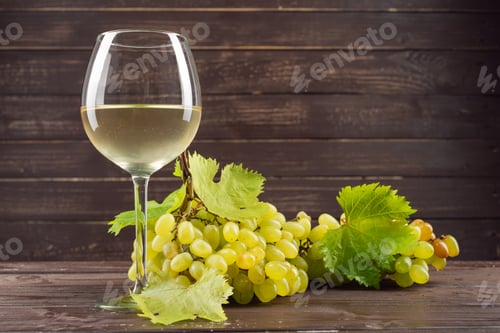 Preview: wine glass and bunch of grapes on wooden table
