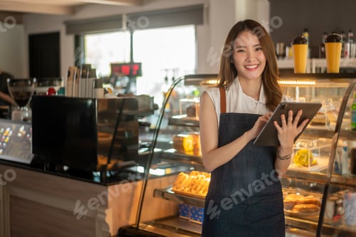 Preview: Woman entrepreneur using tablet checking stock in modern coffee shop