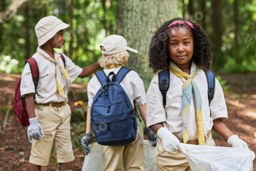 Preview: Cute black girl as scout helping clean forest and holding trash bag
