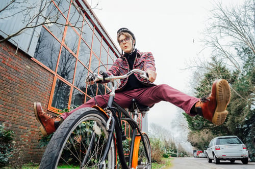 Preview: Male student in helmet on cruiser Bicycle spreading wide legs and screaming when riding bike