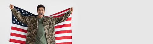 Preview: Wide Horizontal Banner With Happy Male Soldier Holding USA Flag In Hands
