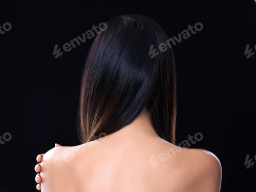 Preview: Rearview studio shot of a model with beautiful brunette hair isolated on black