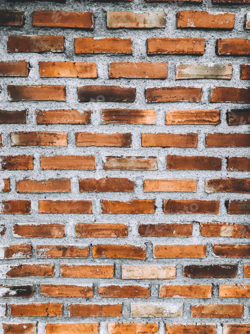 Preview: Close-up of orange brick wall and peeled paint caused by water and sunlight.