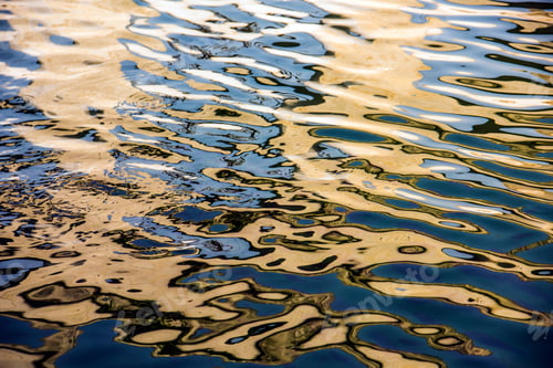 Preview: Water surface with moving wave of golden water reflecting sunlight