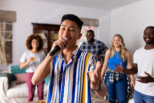 Preview: Happy diverse friends dancing and karaoke singing with microphone at home