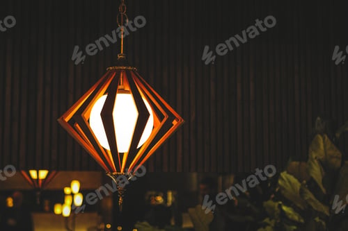 Preview: Midcentury modern lamp with angular shapes in a dark room with wood in the background