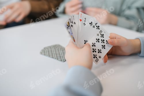 Preview: Friends playing cards at home having fun together