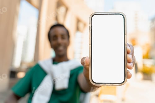 Preview: Smiling African American man showing blank white mobile phone screen, mockup, place for text
