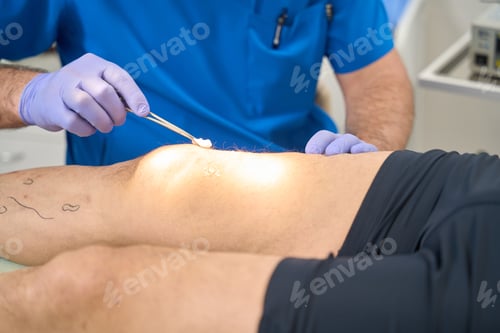 Preview: Doctor who disinfects skin on patient leg