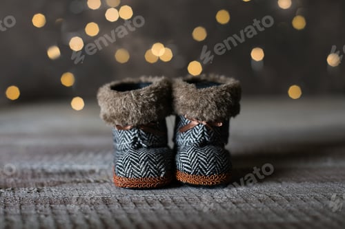 Preview: Holiday Christmas Baby Toy Small Boots on Wooden Table Background. Cozy Concept.
