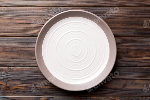 Preview: Top view of empty light plate on wooden background. Empty space for your design