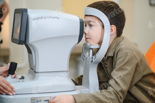Preview: Boy undergoing eyesight examination with autorefractor in ophthalmology clinic