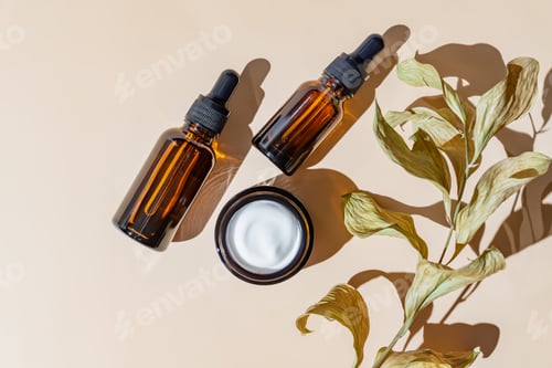 Preview: Face and eye moisturizer cream and serum in a glass bottles and jar and dried herb on light beige