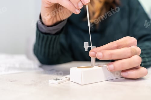 Preview: Closeup shot of a female conducting an at-home covid antigen test