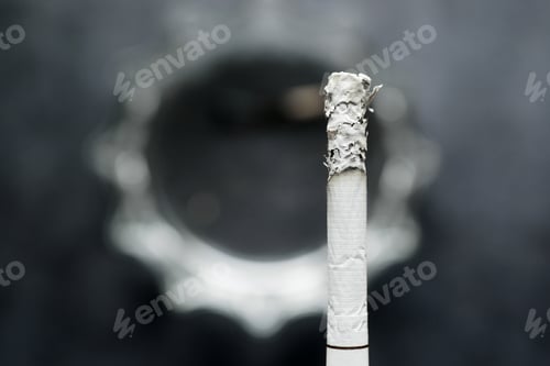 Preview: close up of burning cigarette on dark background