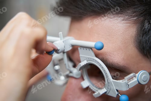 Preview: Doctor doing trial frame height adjustment for patient