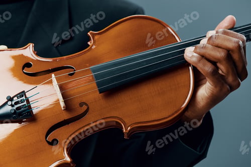 Preview: Close up of musician playing violin on blue background with book