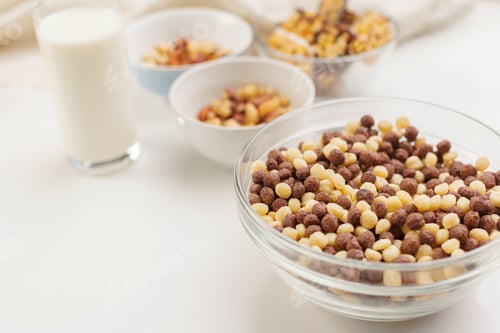 Preview: Bowl of cereal with milk and various snacks on a table