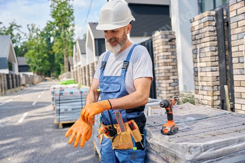 Preview: Smiling builder preparing for masonry work on construction site