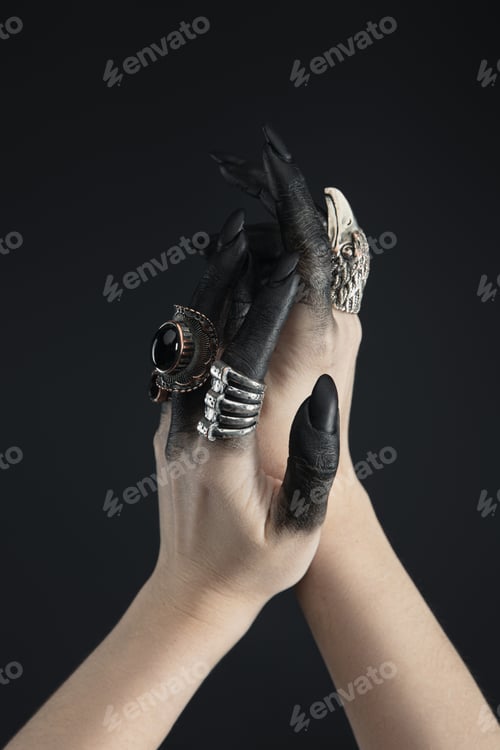 Preview: Cropped view of hands of witch with jewelry rings and black dye isolated on black