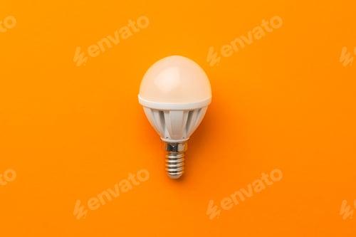 Preview: Light bulb on bright orange background top view