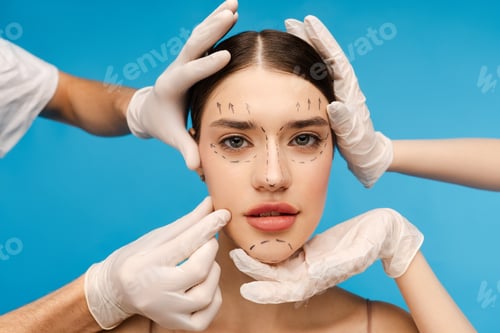 Preview: Pretty young woman ready for plastic surgery. Isolated on blue background. Beauty care