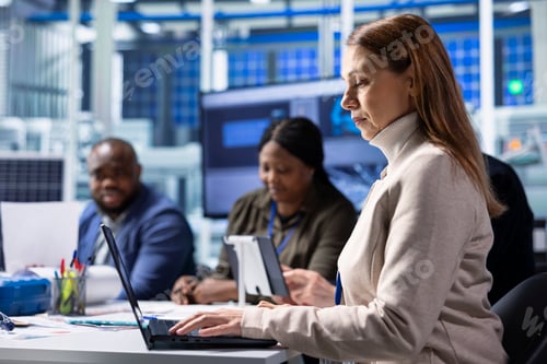 Preview: Investor in photovoltaics factory monitoring system performance on laptop