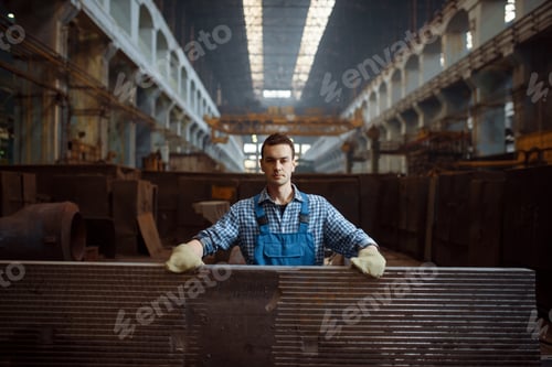 Preview: Male worker at stack of metal workpieces