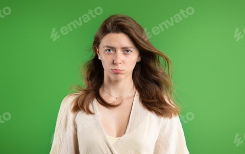 Preview: Portrait of offended upset sad young european lady in casual, sad, isolated on green studio