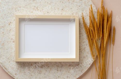 Preview: blank photo frame with pampas grass on marble stand at peach table