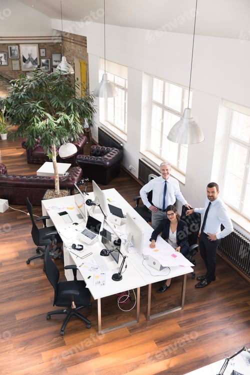 Preview: Team of business people in planning office working on blue print