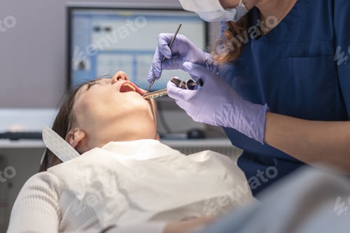 Preview: The dentist cleans the patient's mouth.