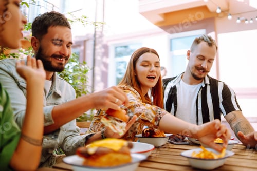 Preview: Group of young friends meeting in a cafe eating fresh tasty burgers. Fast food. People.