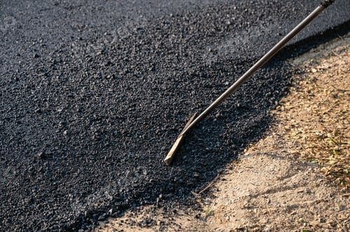 Preview: Construction worker using tool spread the hot-mix asphalt road accurately level covering on highway