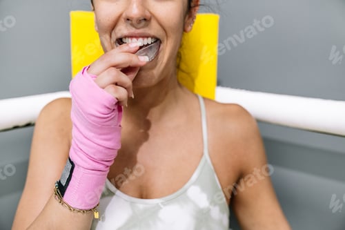 Preview: A young girl putting on a mouth guard before boxing training
