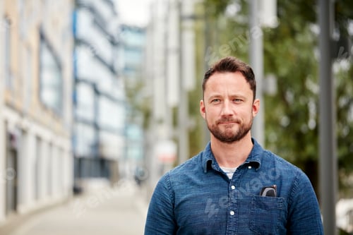 Preview: Man with a beard standing outdoors in a city on a quiet street
