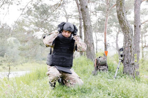 Preview: A man in a military uniform and a bulletproof vest works in the forest to demine the territory