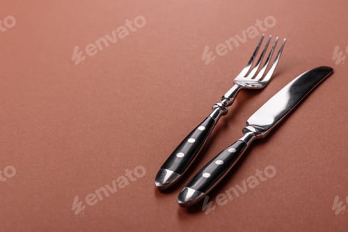 Preview: Knife and fork, cutlery on a brown dining table