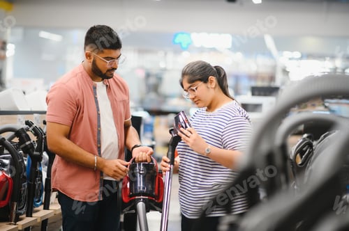 Preview: A young Indian couple buys a vacuum cleaner at an electronics store