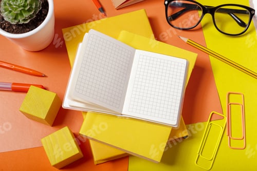 Preview: Workspace setup with notebooks, pens, and a plant on a colorful table