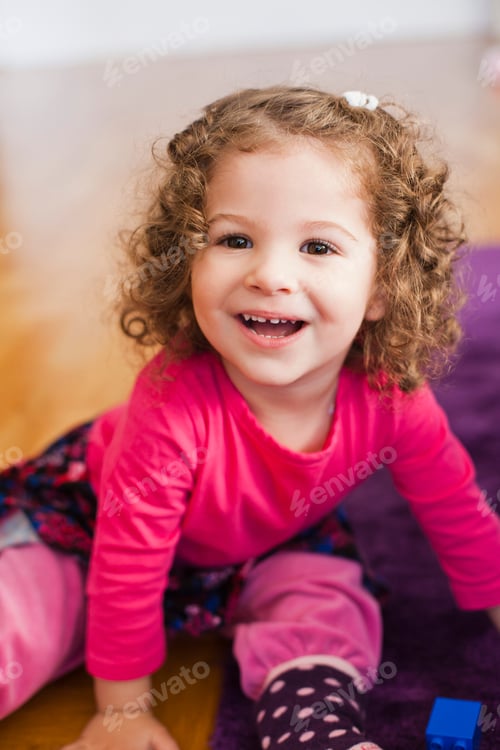 Preview: High angle view of happy girl sitting at home