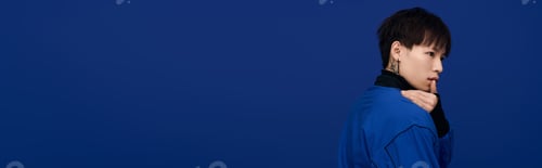 Preview: Captivating young asian man poses thoughtfully against a striking blue background