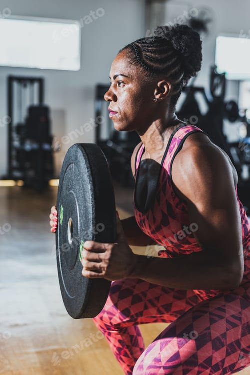 Preview: a woman squatting on the ground with a barbell
