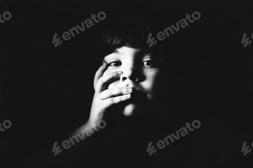 Preview: Child Face Partially Obscured in Dark Setting