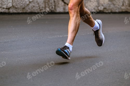 Preview: close-up legs male runner running on gray asphalt marathon race