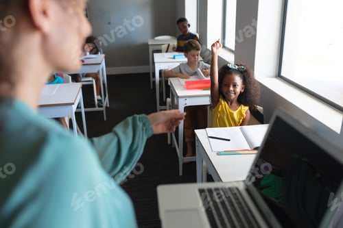 Preview: Caucasian young female teacher pointing on african american elementary schoolgirl with hand raised